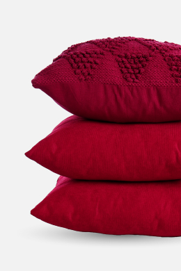 Three red cushions stacked linking to cushions page