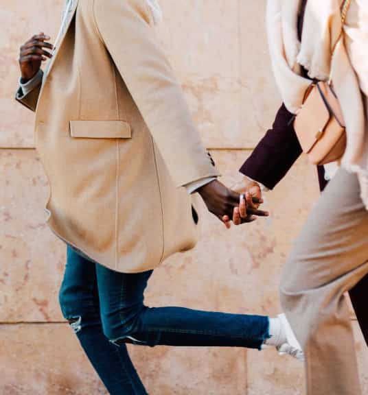 A person wearing a tan blazer and a person wearing a beige scarf holding hands linking to Instagram