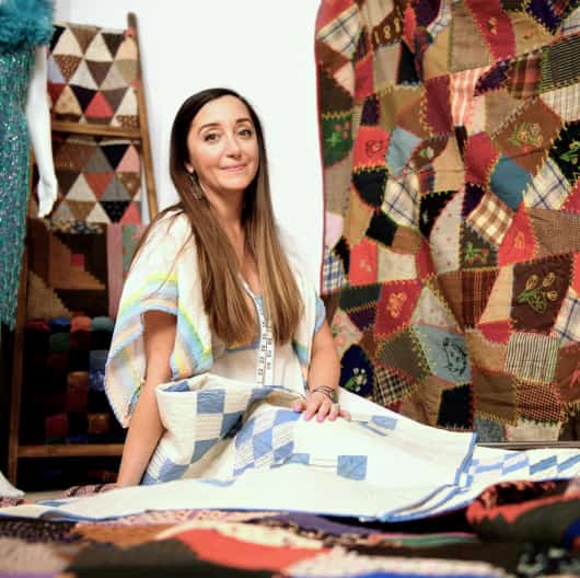 A woman sitting with a pile of patterned fabric around her linking to an eBay inc article