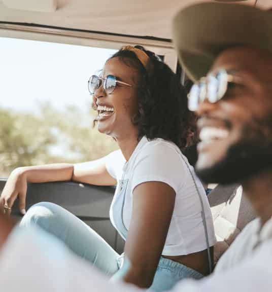 Two people smiling in a car linking to extra 15% off auto parts shopping event