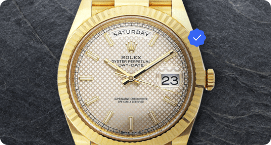 A gold watch on a gray textured background.