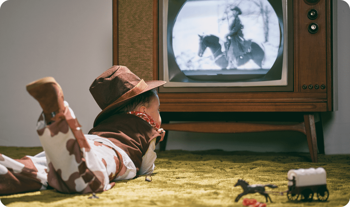 Kid in cowboy costume watching cowboy show linking to retro toys page