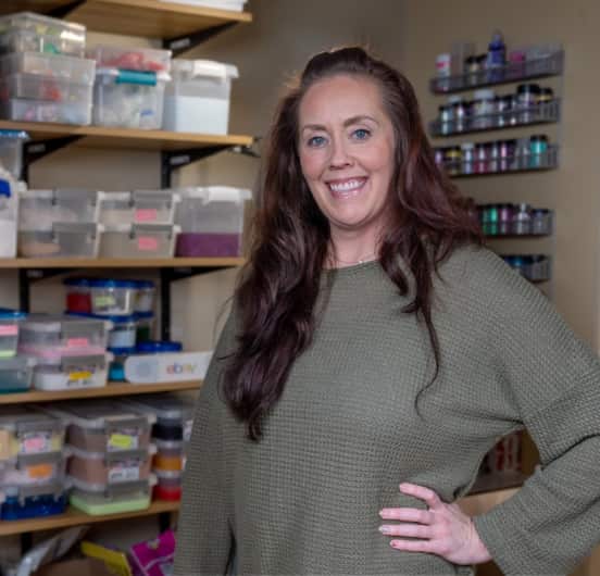 A woman wearing a green top smiling linking to an eBay inc. article