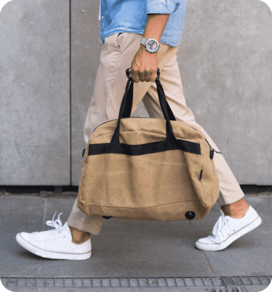 Man walking with duffel bag linking to men's fashion products