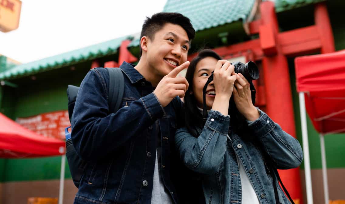 A man pointing and a woman holding a camera linking to eBay Refurbished page