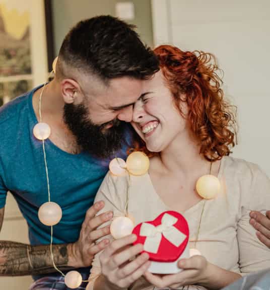 Two people hugging and smiling linking to Valentine's Day gifts page