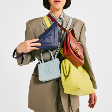 A woman draped with colorful luxury handbags. Links to Fashion page.