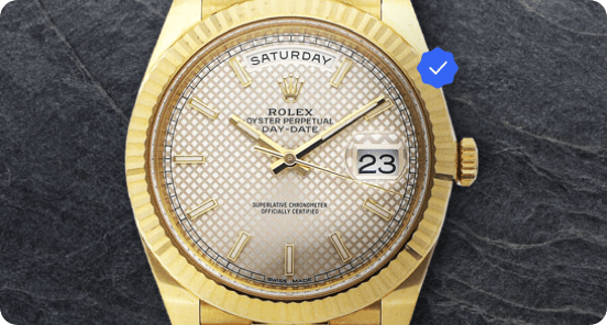 Gold Rolex on dark grey textured surface.