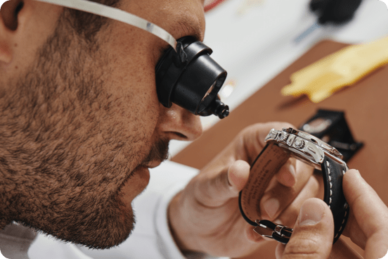 An authenticator inspects a watch.