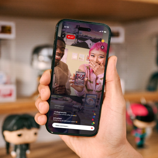 A closeup shot of a hand holding an iPhone showing an eBay Live stream.